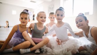 young ballet girls posing for picture relaxing after recital