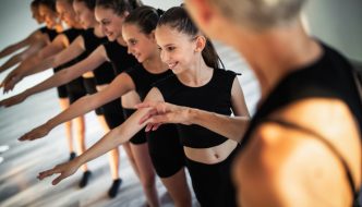 group of teen girl ballerinas in class with dance instructor
