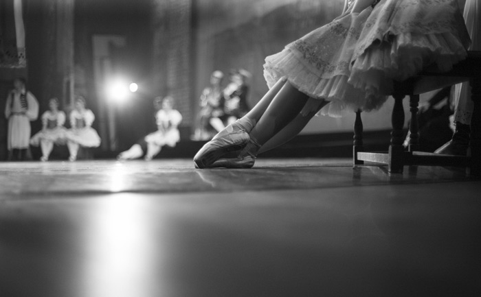ballerina resting her tired feet after performance conclusion