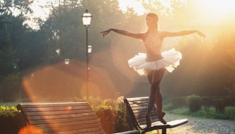 ballerina walking on a park bench