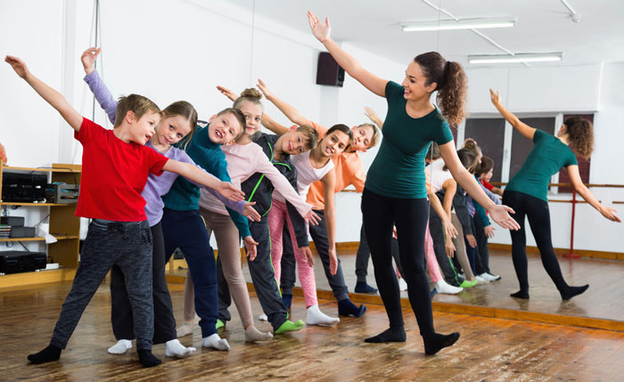 coed dance class stretching with dance instructor
