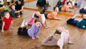 dance instructor helping boy and girl dance students with positioning