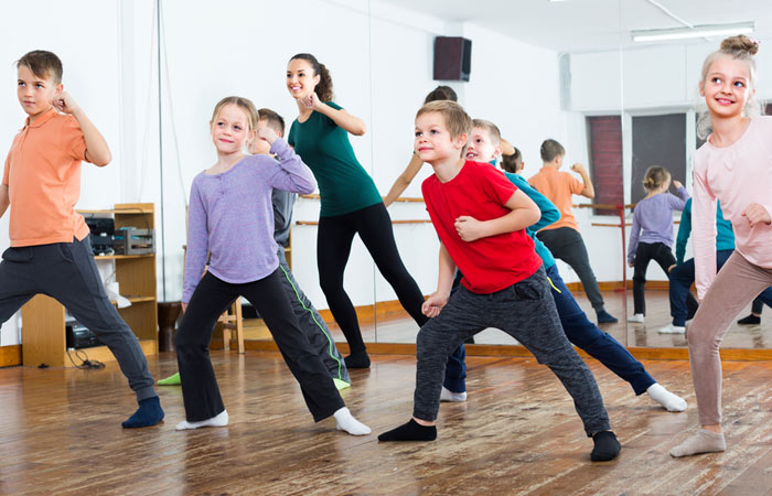 instructor doing warmups with young dance students