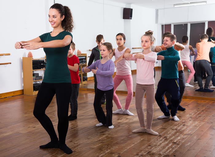 male and female dance students copying dance instructor