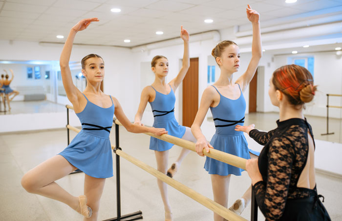 teen girl ballet students in blue practicing moves