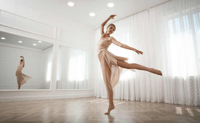 young adult woman ballerina intensely practicing on floor