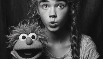 black and white portrait of puppet with teen girl ventriloquist
