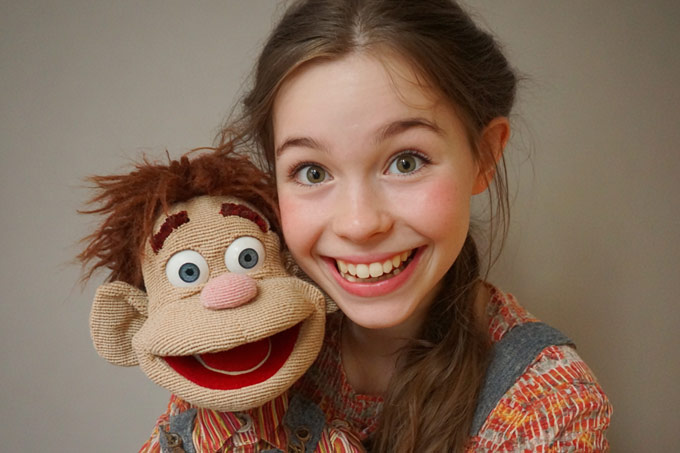 happy teen ventriloquist girl student portrait with her vent figure
